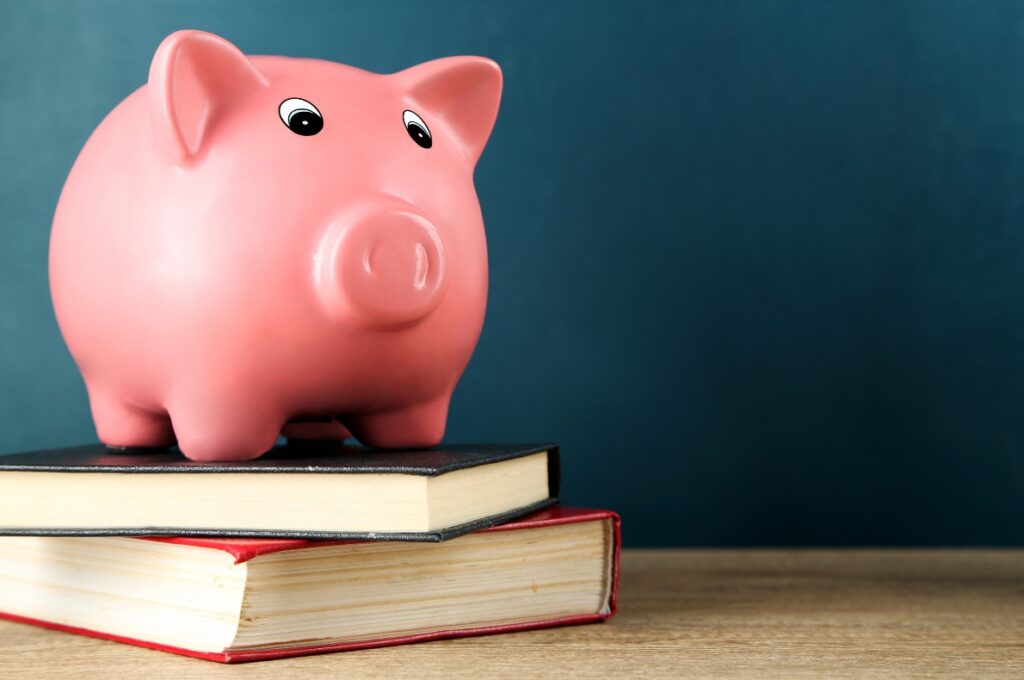 Sparegris på bøker som illustrerer research for å finne beste refinansiering
